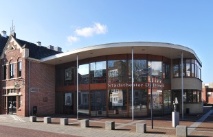 Stadstheater De Bond in een modern en historisch gebouw, gezien vanaf de straat op een zonnige dag.