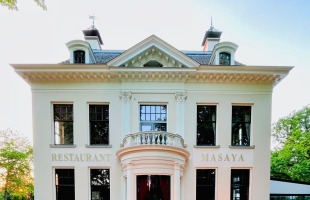 Vooraanzicht van Restaurant Masaya, gevestigd in een wit historisch herenhuis met sierlijke architectuur.