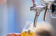 Nahaufnahme, wie Bier bei einer Veranstaltung aus einem Zapfhahn in ein Glas mit 'Rigters' eingeschenkt wird.