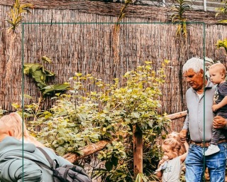 Familie geniet van ontdekkingstour in avonturenpark, met kinderen, gids en groene, natuurlijke omgeving.