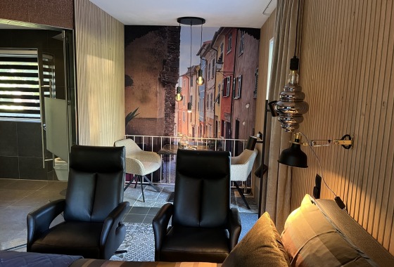 Een moderne woonkamer met zwarte stoelen en een trompe-l'oeil muurschildering van een straatje.
