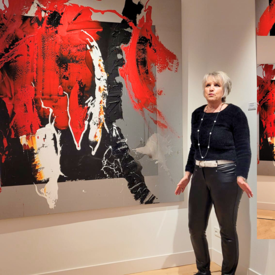 Frau im schwarzen Outfit steht neben großem abstraktem Gemälde in Rot, Schwarz und Weiß in moderner Galerie.