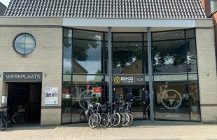 Fietsenwinkel Bike Totaal SOK met grote glazen voorgevel en werkplaatsingang aan de linkerzijde.