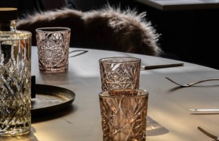 Stijlvolle eettafel met luxe glazen, gouden bestek en stoelen bekleed met zacht imitatiebont.