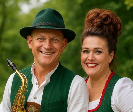 Man en vrouw in traditionele Beierse klederdracht poseren samen buiten; man houdt een saxofoon vast.