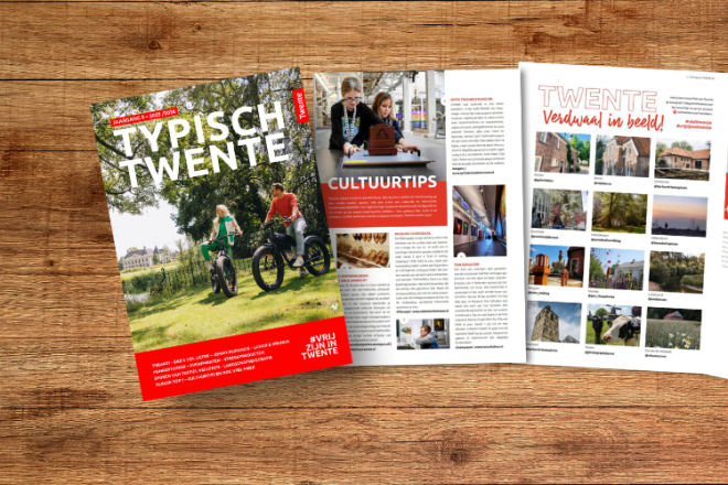 Een tijdschrift getiteld 'Typisch Twente' ligt open op een houten tafel, met pagina's over cultuur.