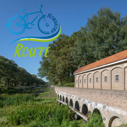 Oud bakstenen gemaal met brug in een groene omgeving op de Apollo Noordroute, zonnige dag.