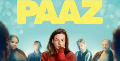 Promotieposter van de serie 'PAAZ' met een vrouw in een rode trui in het midden van een groep mensen.