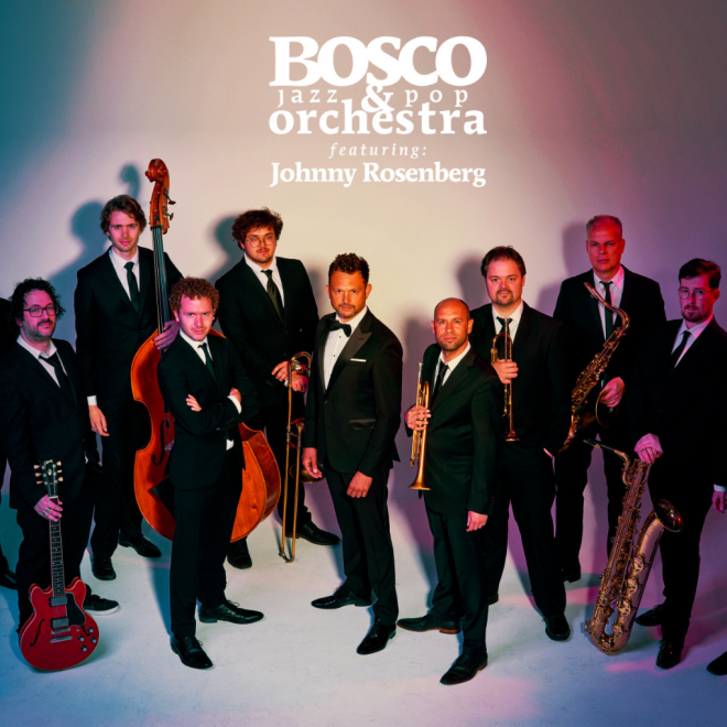 Gruppenfoto des BOSCO Jazz & Pop Orchestra mit Johnny Rosenberg, alle Musiker im Anzug mit ihren Instrumenten.